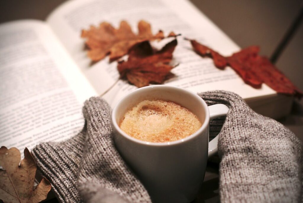 un bon café chaud, un livre et quelques feuilles orangées